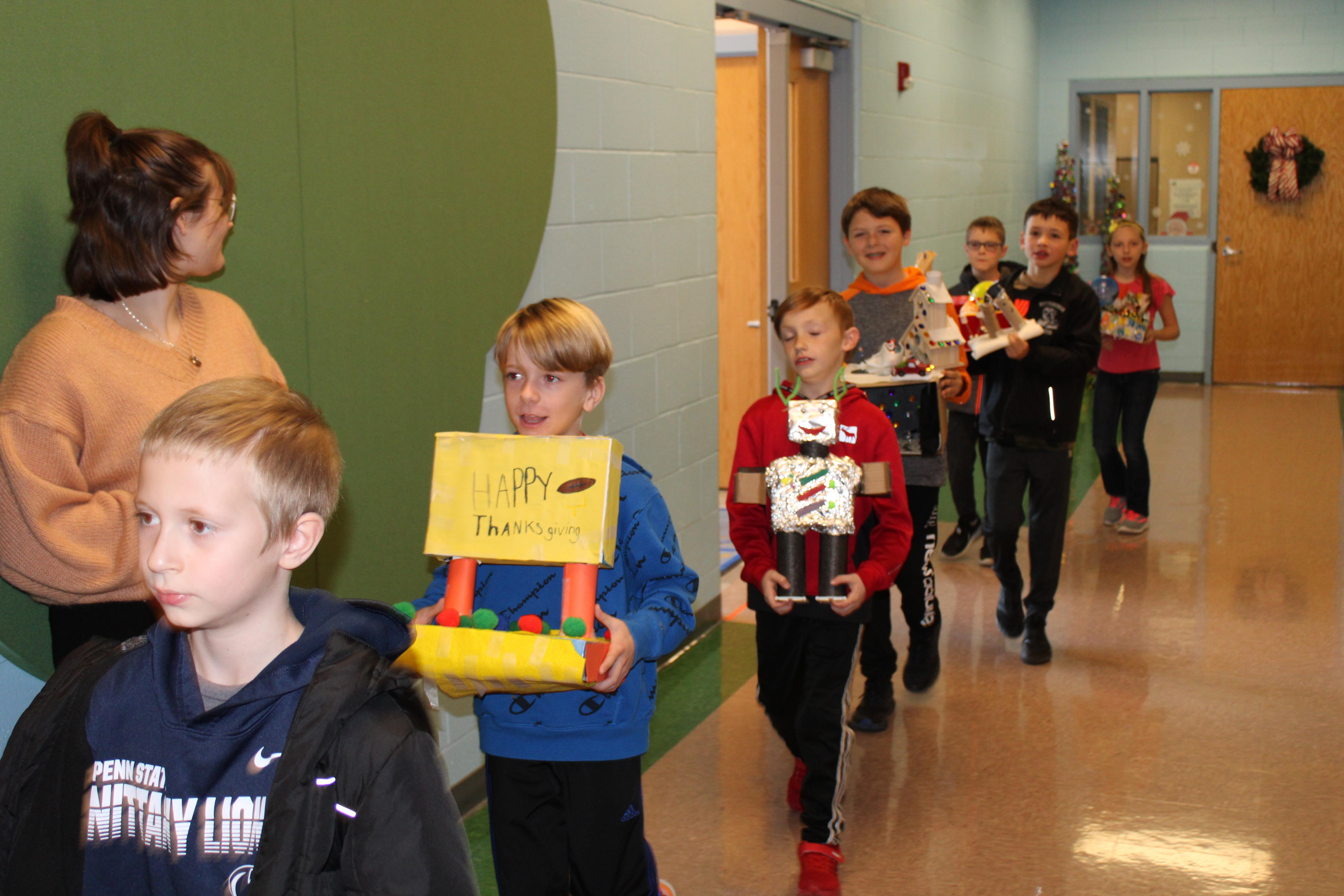 pic of kids carrying small "floats" down the hall